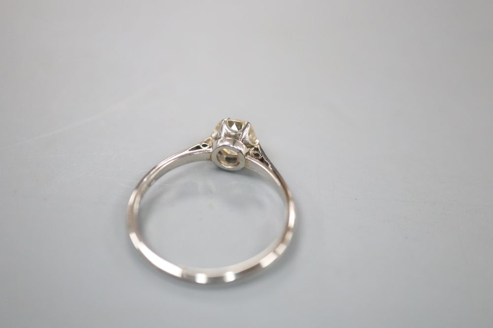 A white metal (stamped platinum) and diamond solitaire ring, size L, gross 2.4 grams.